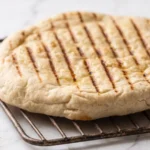 Saftiges Grillbrot vom Rost frisch gebacken — Teigfladen mit Olivenöl und dunklen Grillstreifen