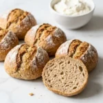 knusprige Sonntagsbrötchen frisch gebacken aus der Froschperspektive — Handwerkliche Kruste der aufsteigenden Brötchen im Fokus.