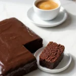 Schokokuchen vom Blech serviert mit frisch gebrühter Kaffee — Ein abgeschnittenes saftiges Kuchenquadrat neben einer Tasse Kaffee.