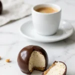 Käsekuchen Kugeln serviert mit frisch gebrühter Espresso — Eine halbierte Cheesecake-Praline zeigt den cremigen Kern neben Kaffee.