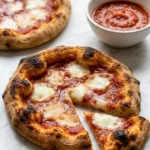 Sauerteig Pizzateig serviert mit Aioli — Ein aufgeschnittenes Stück Pizza zeigt die dünne, krosse Kruste und den luftigen Rand.