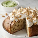 Kleiner Rhabarberkuchen mit Baiser serviert mit Bärlauchbutter — aufgeschnittenes Kuchenstück mit saftiger Rhabarberschicht