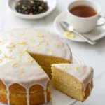 Zitronenkuchen serviert mit Earl-Grey-Tee — saftiger Kuchen mit Glasur neben einer Tasse Tee.