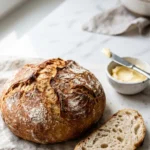 Ratz-Fatz-Brot serviert mit Butter — Ein abgeschnittener Keil des warmen Brotes zeigt die fluffige, weiche Krume.