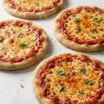 Sauerteig-Pizza frisch gebacken — knusprige homemade Pizza mit geschmolzenem Käse und Tomatensauce auf weißem Marmor.