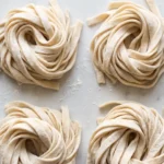 Frische Sauerteig-Pasta selber machen — hausgemachte Nudelnester auf bemehlter Fläche