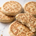 Schnelles Pfannenbrot ohne Hefe frisch gebacken — krosse, runde Brotfladen mit typischen Backflecken auf weißem Marmor.