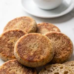 Sauerteig-Pfannkuchen frisch gebacken — krosse, dünne Kräuter-Pfannkuchen im Stapel auf weißem Marmor.