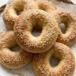 Bagels frisch gebacken — goldbraune Kruste mit weißem Sesam, locker angerichtet