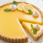 Klassische französische Tarte au Citron auf Tortenplatte — spiegelglatte gelbe Zitronencreme mit feinem Mürbeteigrand
