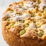 Stachelbeer-Streusel-Kuchen frisch gebacken — runder Quarkkuchen mit goldgelben Streuseln und feiner Puderzuckerdecke.