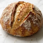 Schnelles Brot mit Trockenhefe frisch gebacken — knuspriges rundes Brot mit tiefen Einschnitten.
