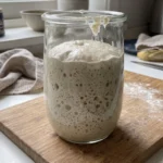 Aktiver, reifer Sauerteig mit vielen Bläschen und verdoppeltem Volumen im Glas.