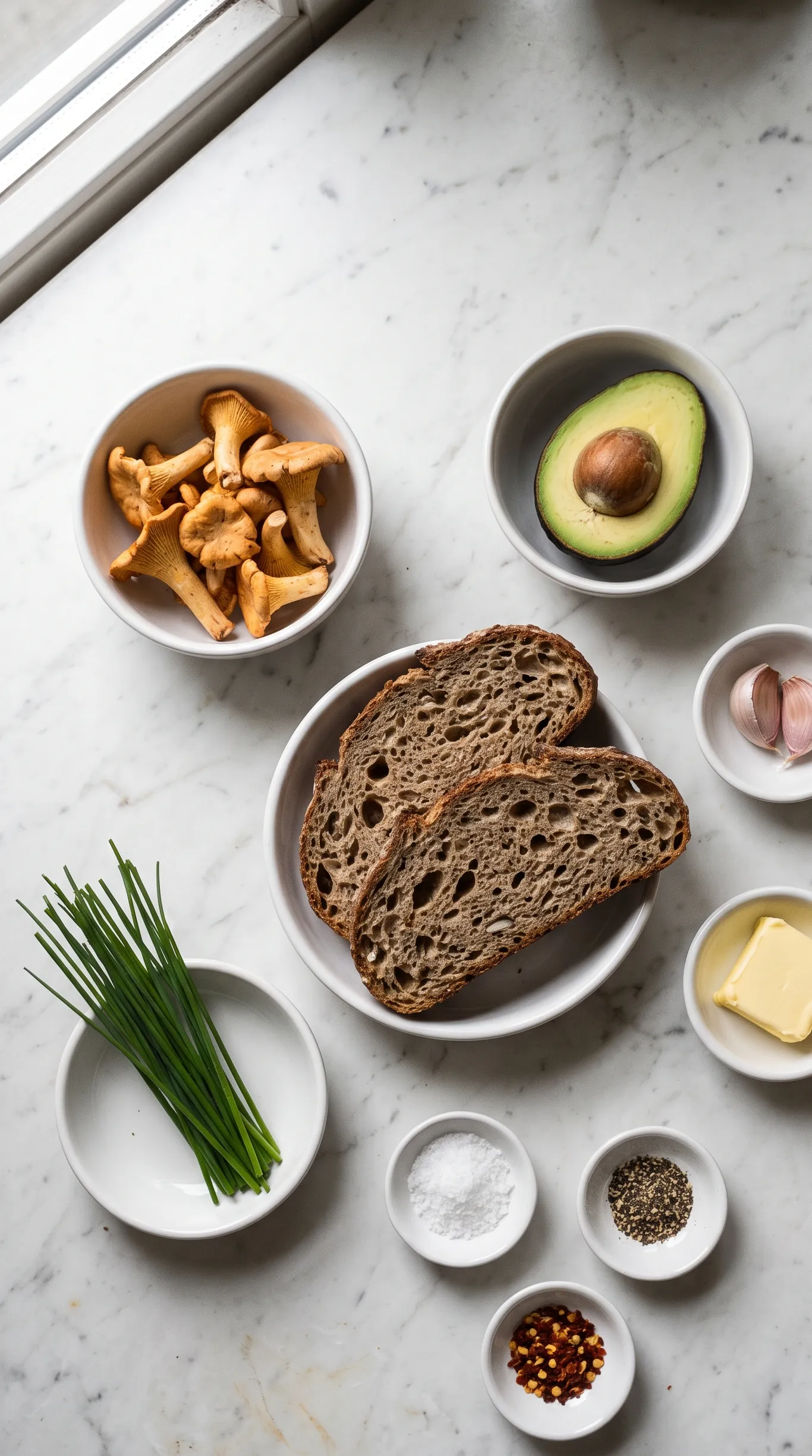 Zutaten für Pfifferling-Brot: Eiweißbrot, frische Pfifferlinge, Avocado, Knoblauch, Butter, Schnittlauch und Gewürze.