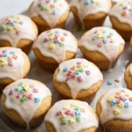 Saftige Einschulungs-Muffins frisch gebacken — mit weißem Zitronenguss und bunten Zuckerbuchstaben