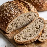 Herzhaftes Sauerkrautbrot mit knuspriger Senfkruste und Saaten, frisch gebacken und angeschnitten auf Holzbrett.
