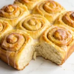 Fluffige Holunderblüten-Schnecken frisch gebacken in der Backform mit feiner Zitronen-Holunderblüten-Glasur.