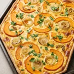 Herzhafter Zwiebel-Kürbis-Kuchen vom Blech mit Schmand, Hokkaidokürbis, Zwiebelringen und frischer Petersilie.