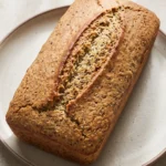 Saftiges glutenfreies Low Carb Brot: Ganzes Kastenbrot mit zart gerissener goldbrauner Saatenkruste.